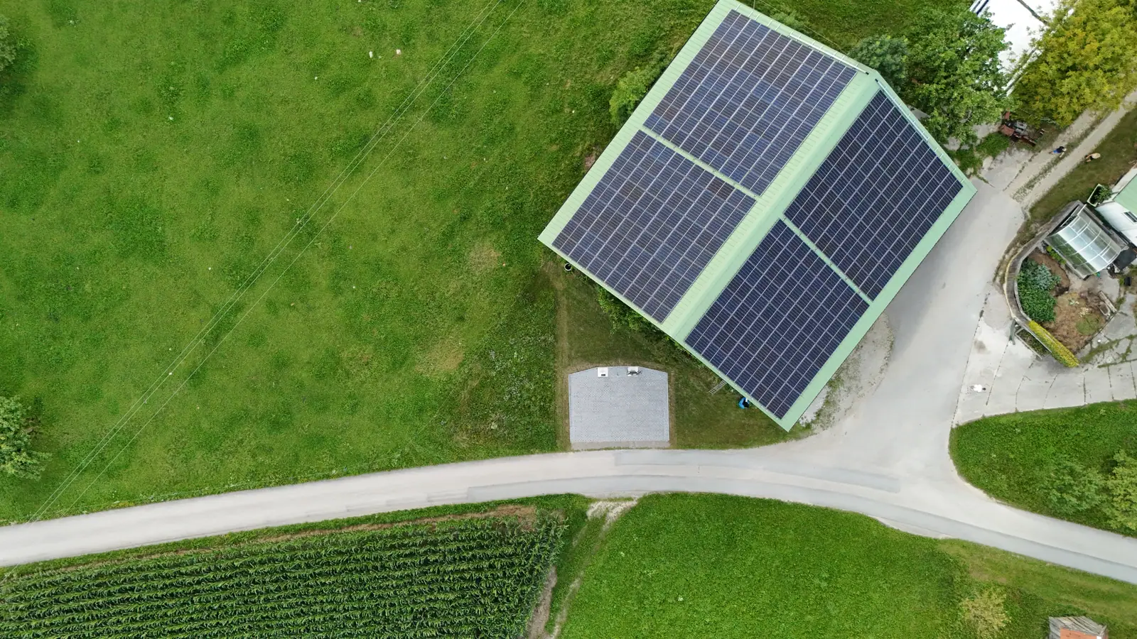 Senkrechte Luftaufnahme einer Scheune mit voll belegtem Photovoltaik-Dach